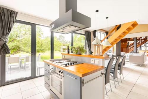 a kitchen with a stove top oven next to a dining room at Superbe et chaleureux gîte familial in Beauraing