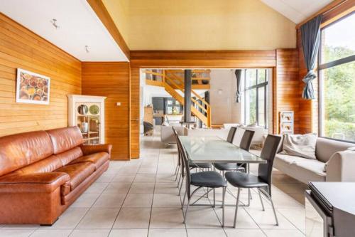 a living room with a couch and a table at Superbe et chaleureux gîte familial in Beauraing