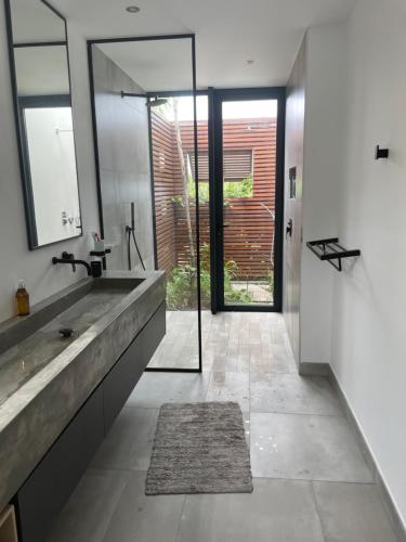 a bathroom with a large sink and a mirror at Villa lagoon view Baie du cap bel ombre in Ruisseau Créole