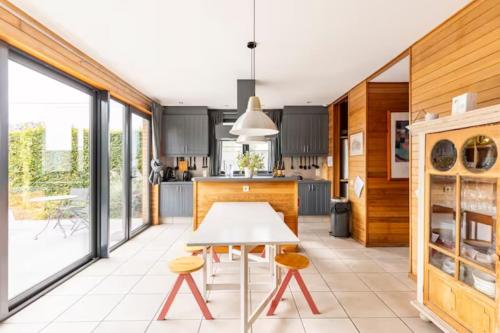 a kitchen with a white table and some chairs at Superbe et chaleureux gîte familial in Beauraing