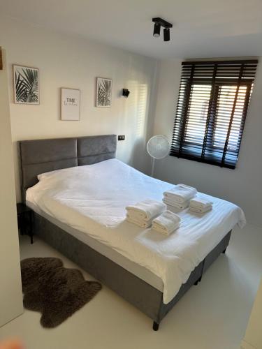 1 dormitorio con 1 cama grande y toallas. en Antwerp West Side, TERRACE en Zwijndrecht
