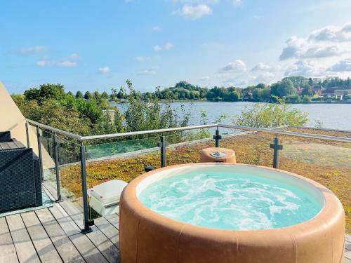 a hot tub on a patio next to a lake at Ringelnatz Inselhotel in Malchow