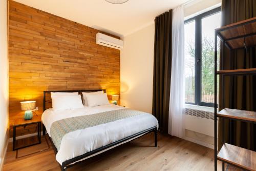 a bedroom with a bed and a wooden wall at Renovated 3-bedroom House in Nature - Iskia Estate in Martvili