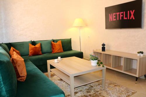 uma sala de estar com um sofá verde e uma mesa em Magnifique Appartement Marrakech - 2 Chambre 2 Salle de Bains em Marrakech