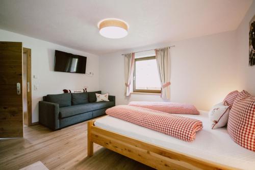 a living room with two beds and a couch at Nedererhof - Zimmer Enzian mit Gemeinschaftsküche in Schmirn