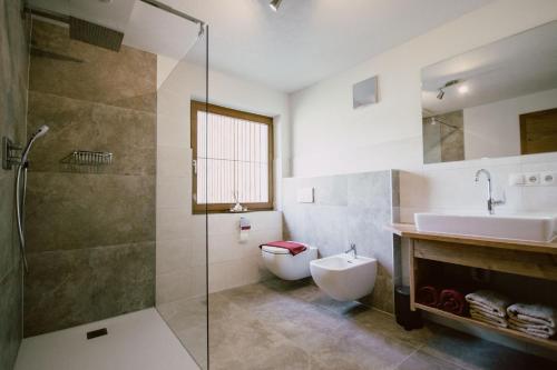 a bathroom with a sink and a toilet and a shower at Nedererhof - Zimmer Enzian mit Gemeinschaftsküche in Schmirn