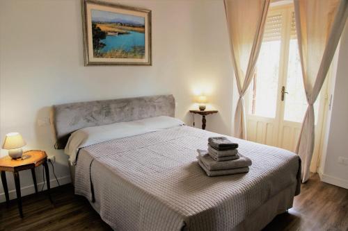 una camera da letto con un letto, due lampade e una finestra di Villa Giardino Sa Tiacca a SantʼAndrea