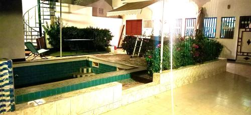 a swimming pool in a house with a fountain at One bedroom appartement with shared pool furnished garden and wifi at M'bour 2 km away from the beach in Mbour