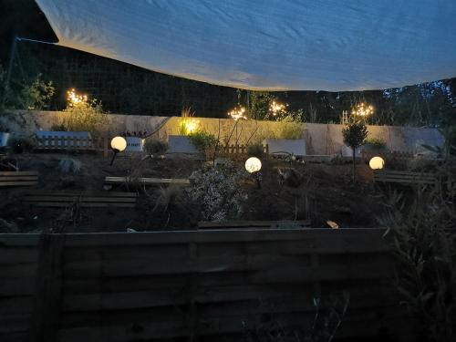 a view of a garden at night with lights at Chez ROSE in Bruyères