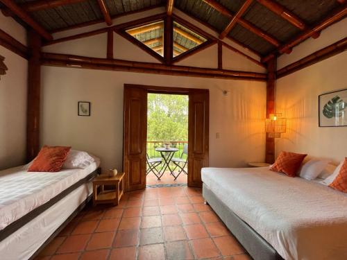 two beds in a room with a window at Finca Hotel Santana in Montenegro