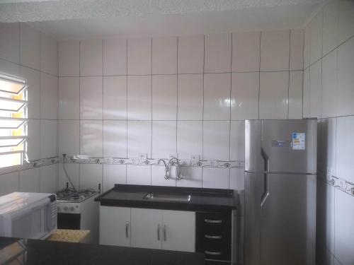 eine Küche mit Kühlschrank und Spüle in der Unterkunft Peruíbe - Oasis - Casa espaçosa, lugar tranquilo in Peruíbe