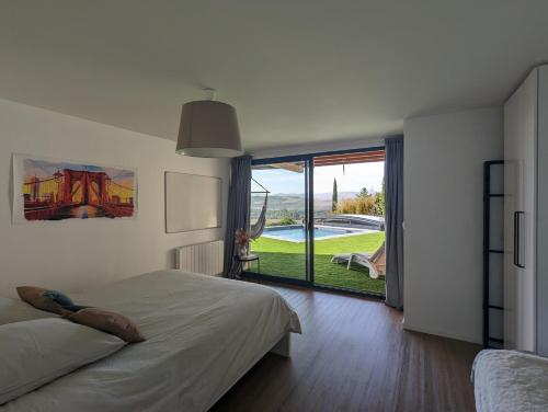a bedroom with a bed and a view of a yard at Bel appartement 75m2 in Mirefleurs