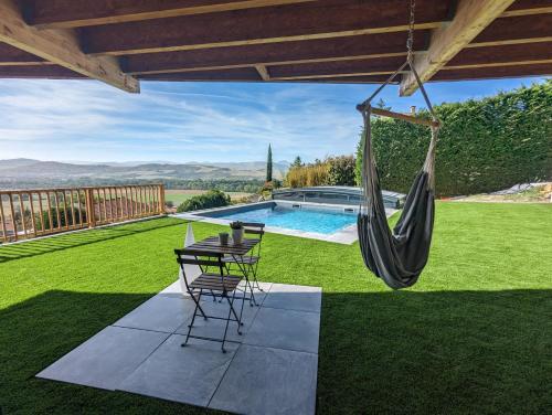 a patio with a hammock and a swimming pool at Bienvenue chez Séverine et julien Appartement 75m2 in Mirefleurs