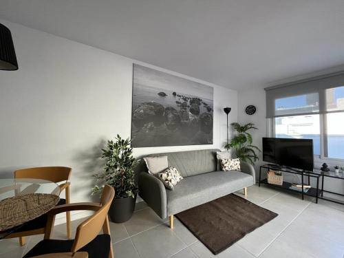 a living room with a couch and a tv at Sunny Cozy & Pretty Penthouse in Central SC in Santa Cruz de Tenerife