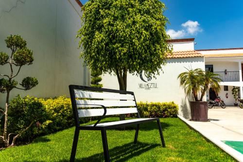 a bench sitting in the grass in front of a house at Villa Meztli in San Juan Teotihuacán