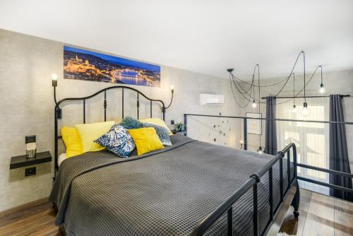 1 dormitorio con 1 cama grande con almohadas amarillas en Luxury apartment in the city center with parking en Budapest