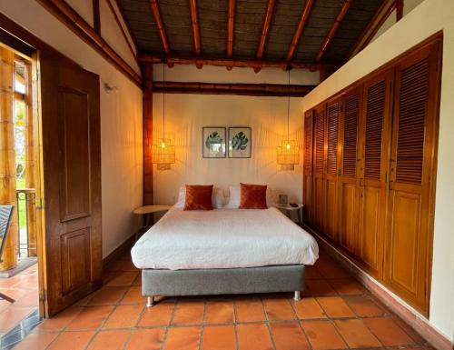 a bedroom with a bed and two tables in it at Finca Hotel Santana in Montenegro