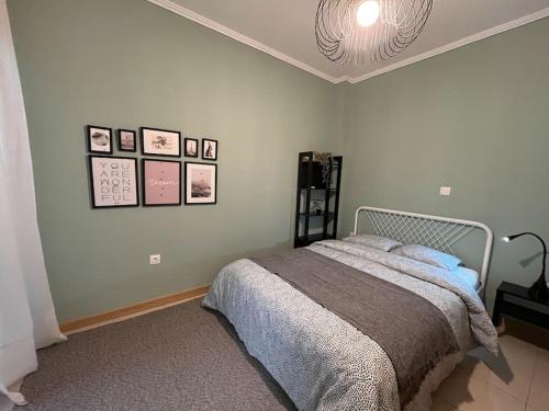 a bedroom with a bed and pictures on the wall at Peaceful, Lovely, 1st floor, condo @Thessaloniki in Thessaloniki