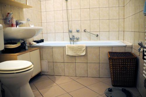 塞格德的住宿－Sunny Apartman，带浴缸、卫生间和盥洗盆的浴室