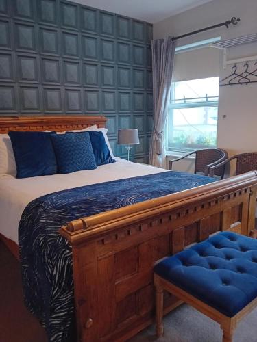 Un dormitorio con una gran cama de madera con almohadas azules en The Baytree Restaurant & Guesthouse, en Carlingford