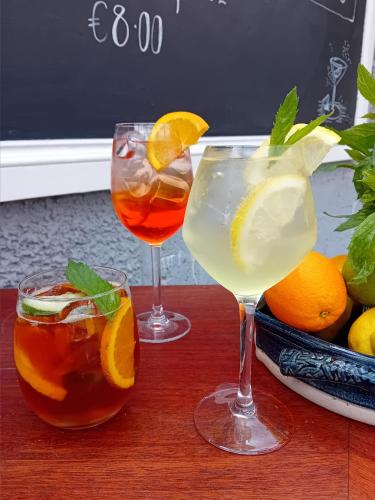 two glasses of drinks on a wooden table with oranges at The Baytree Restaurant & Guesthouse in Carlingford