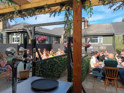 a group of people sitting at a restaurant under a pergola at The Baytree Restaurant & Guesthouse in Carlingford