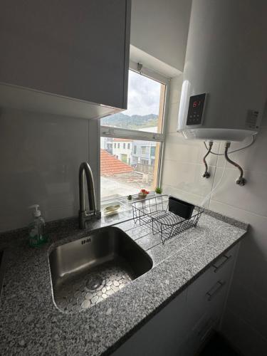 a kitchen counter with a sink and a window at Sun Beach Apartment in Machico