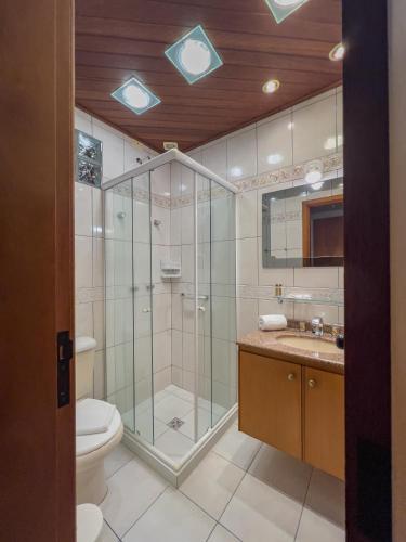 a bathroom with a shower and a toilet and a sink at Hotel Palazzo Reale in Campos do Jordão