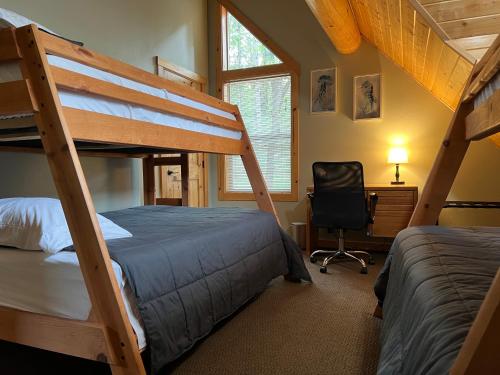 a bedroom with two bunk beds and a desk at Shasta Lake Luxury Log Cabin: Hot tub & Pool in Lakeshore