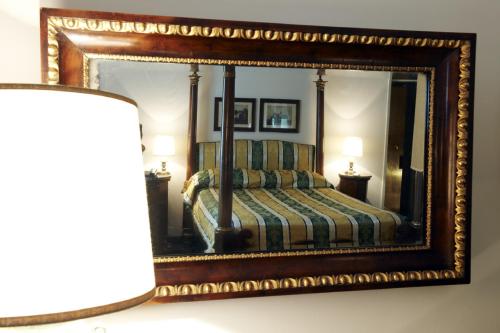a bedroom with a bed in a mirror at Park Palace Hotel in Florence