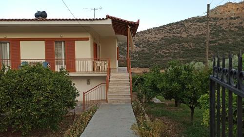 a house with stairs and a fence in front of it at O'GERA Greek resort house in the mountains in Kókla