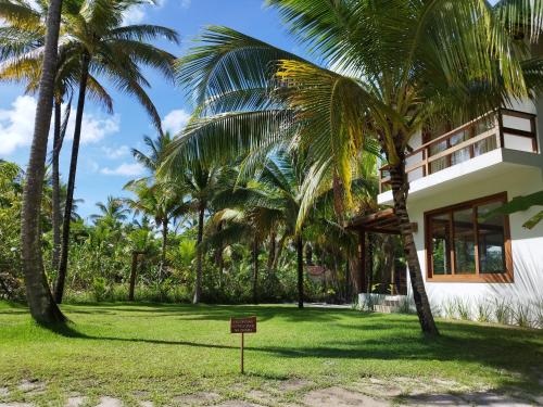a sign in front of a building with palm trees at Kíria's Village Beach House in Marau
