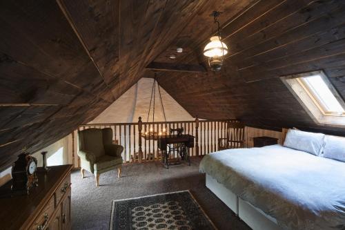 een slaapkamer met een bed en een bureau op zolder bij Maggie Deenys Cottage 