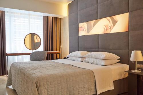 Habitación de hotel con cama grande y espejo en Brasil Suites Boutique Hotel, en Atenas