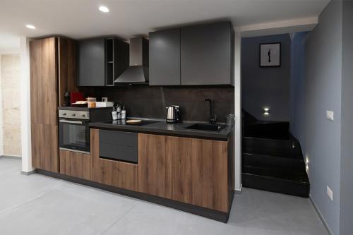 a kitchen with black and wooden cabinets and a stove at San Giacomo Loft Apartment in Barletta