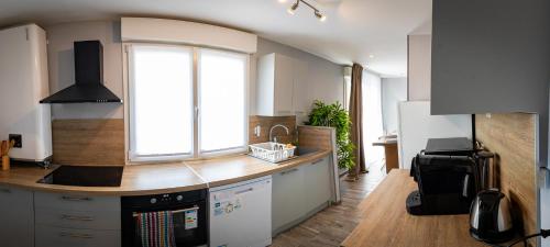 a kitchen with a counter and a large window at Résidence Hera Paris Orly Aéroport in Villeneuve-le-Roi