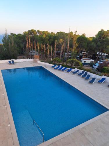 a large swimming pool with lounge chairs at La calma de Tossa in Girona