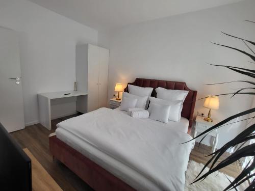 1 dormitorio con 1 cama grande con sábanas y almohadas blancas en Sika Sunny Garden Apartment, en Arad