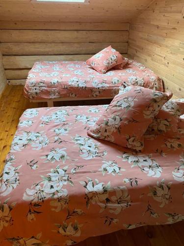 - 2 lits dans une chambre avec des draps et des oreillers roses dans l'établissement Luobos vienkiemis, à Luoba