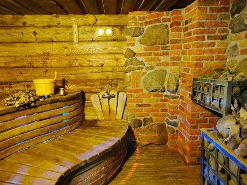 um banco de madeira num quarto com uma parede de tijolos em Luobos vienkiemis em Luoba