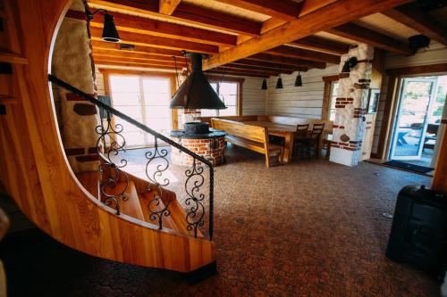 a wooden room with a wooden table and a spiral staircase at Luobos vienkiemis in Luoba