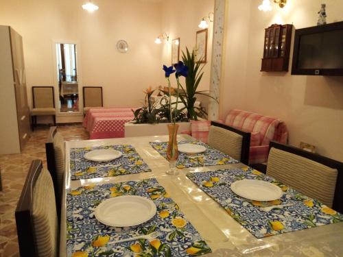 een eettafel met borden en bloemen erop bij Da Giusy le petit bijou in Castelbuono