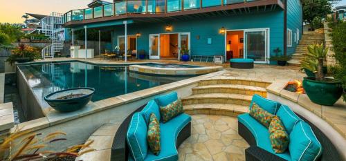 a house with a swimming pool with blue chairs at Breathtaking La Playa Getaway With Golf Cart Use! in San Diego