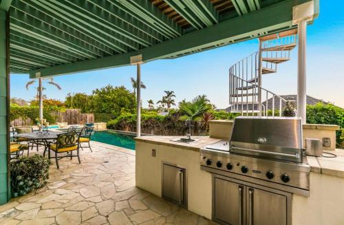 an outdoor kitchen with a patio with a table and a pool at Breathtaking La Playa Getaway With Golf Cart Use! in San Diego