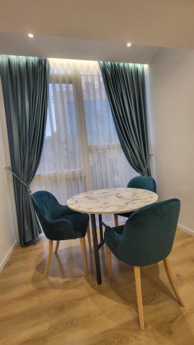 a table and two chairs in a room with a window at Karanxha's room in Tirana