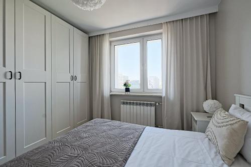 Metropolitan Heaven Apartment Emilii Plater 55 tesisinde bir odada yatak veya yataklar