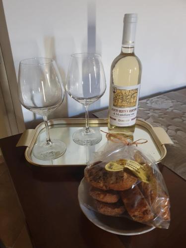 a tray with a bottle of wine and two wine glasses at Il tempio di Medusa in Zepponami