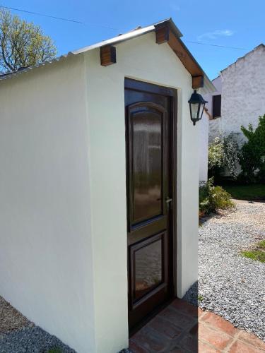 a door in a white wall with a light next to it at Apart Los Cerrillos in Balcarce