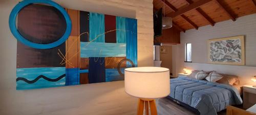 a bedroom with a bed and a large painting on the wall at Apart Los Cerrillos in Balcarce