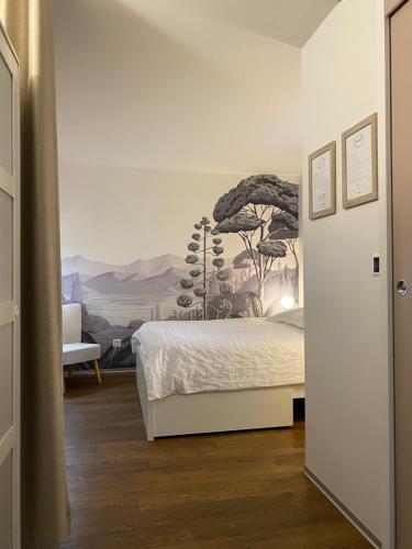 - une chambre avec un lit et une peinture murale dans l'établissement Chaleureux studio entre Neuchatel et Bienne, à Le Landeron